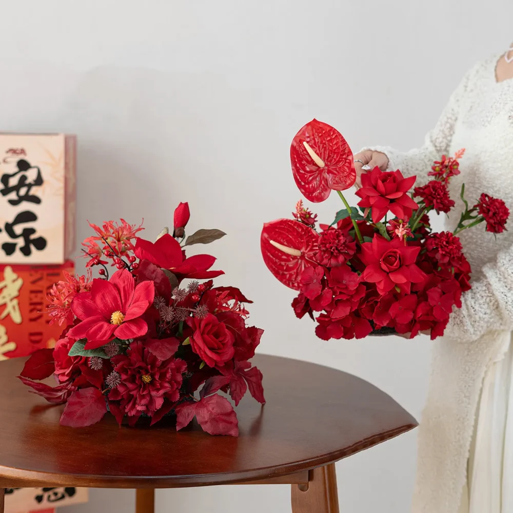 Red anthurium red artificial flower table arrangement in a low black base, styled in a room setting