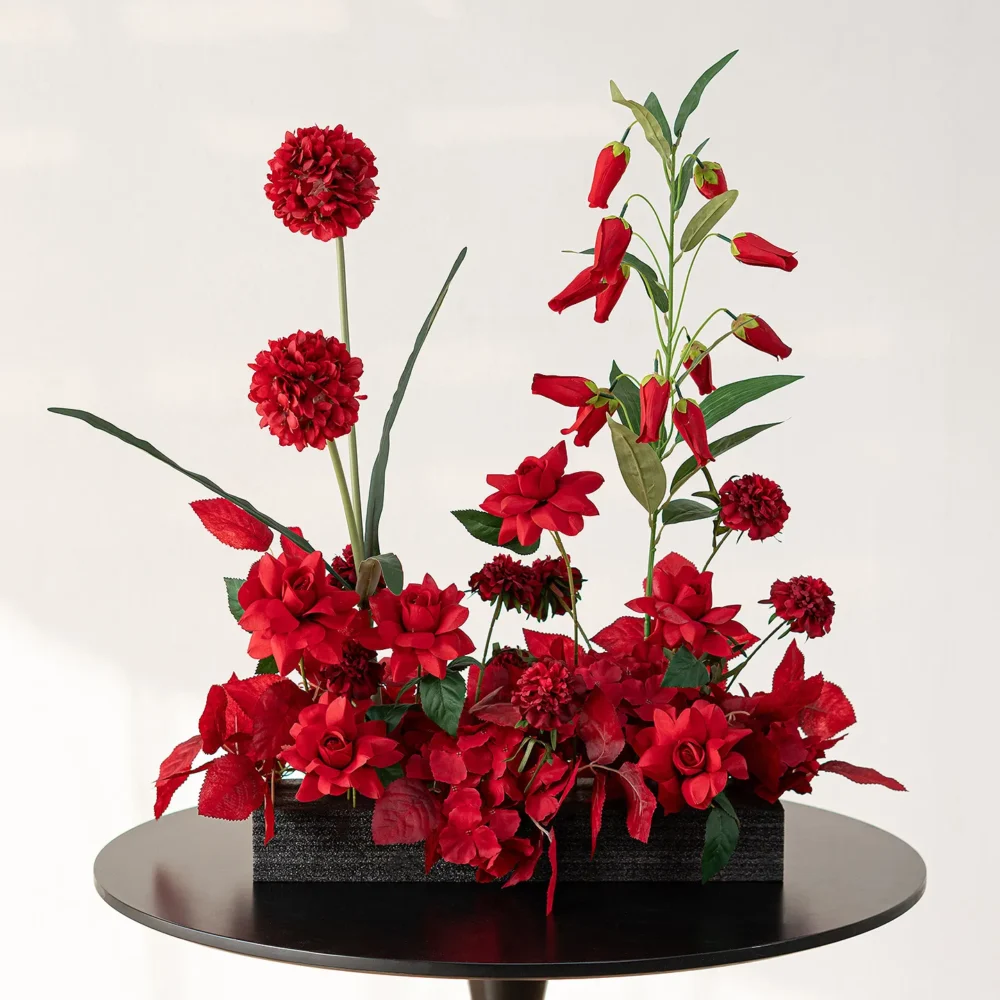 Red chilli red artificial flower table arrangement in a low black base