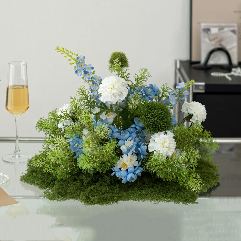Blue and white artificial round table centrepiece on a moss-covered base, finished on all sides