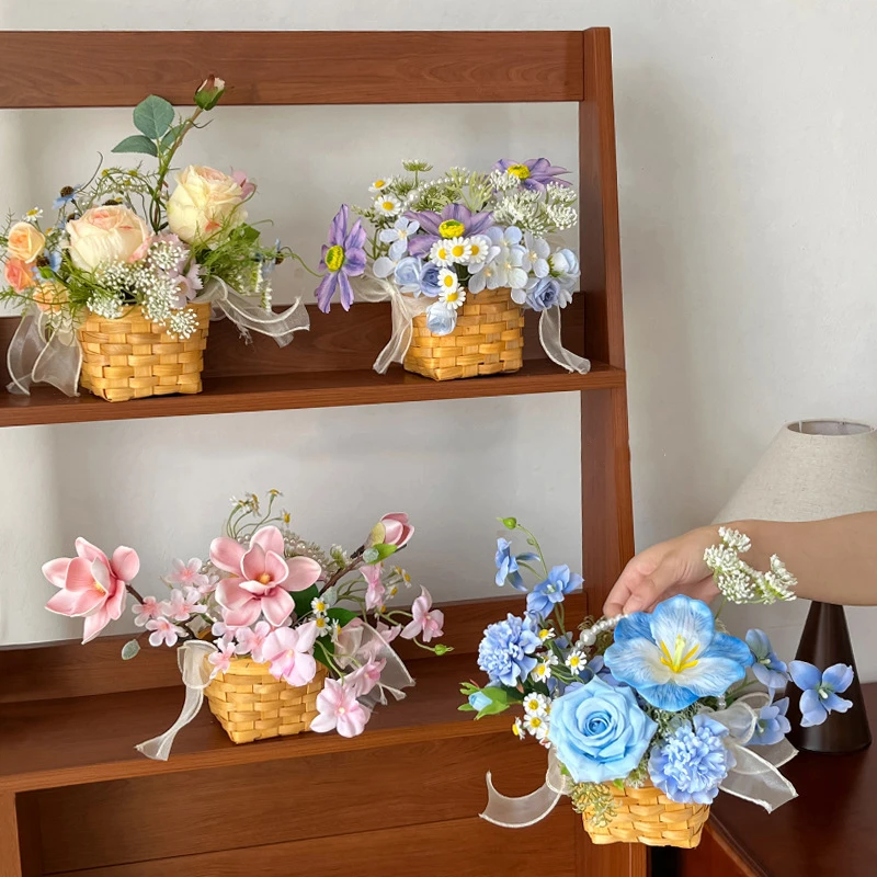 Small artificial flower gift basket tied with a wide organza bow with the full colour range