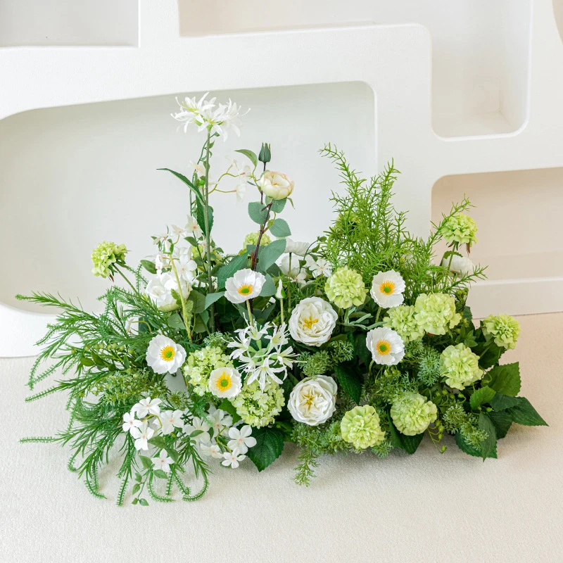 Ivory and green artificial wedding arch arrangement built long and low as a one-sided run, styled on a table top