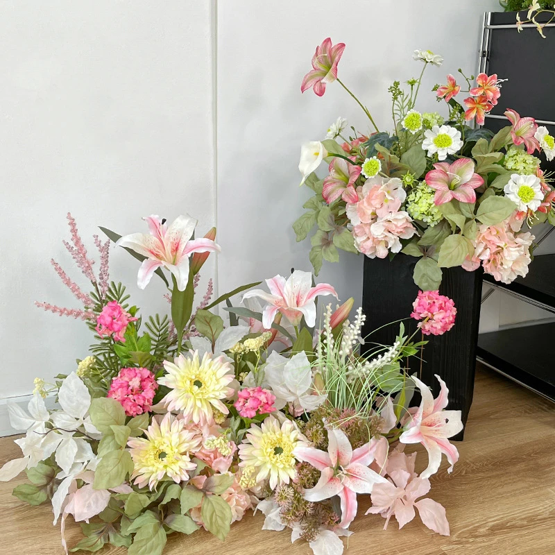 Artificial wedding arch arrangement built long and low as a one-sided run, styled in a room setting