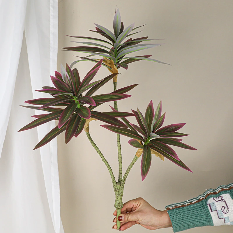 Deep burgundy artificial branching plant stem forking into three to five heads on one stem, held in one hand