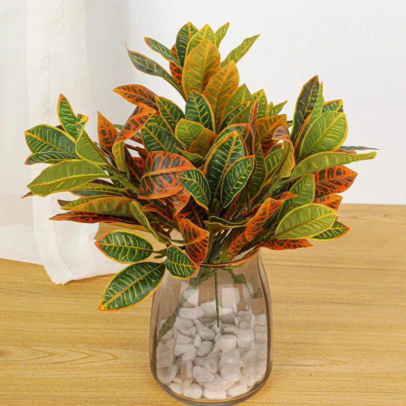 Autumn, in a vase artificial croton leaf stem with leathery leaves marked in two or three colours, arranged in a vase