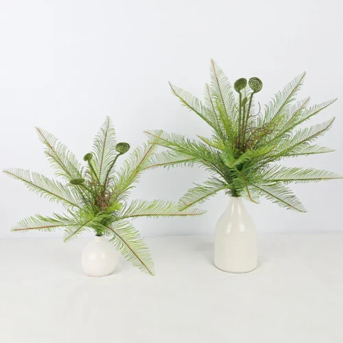 Two in white vases artificial fern bush with coiled fiddleheads left unopened among the fronds, arranged in a vase