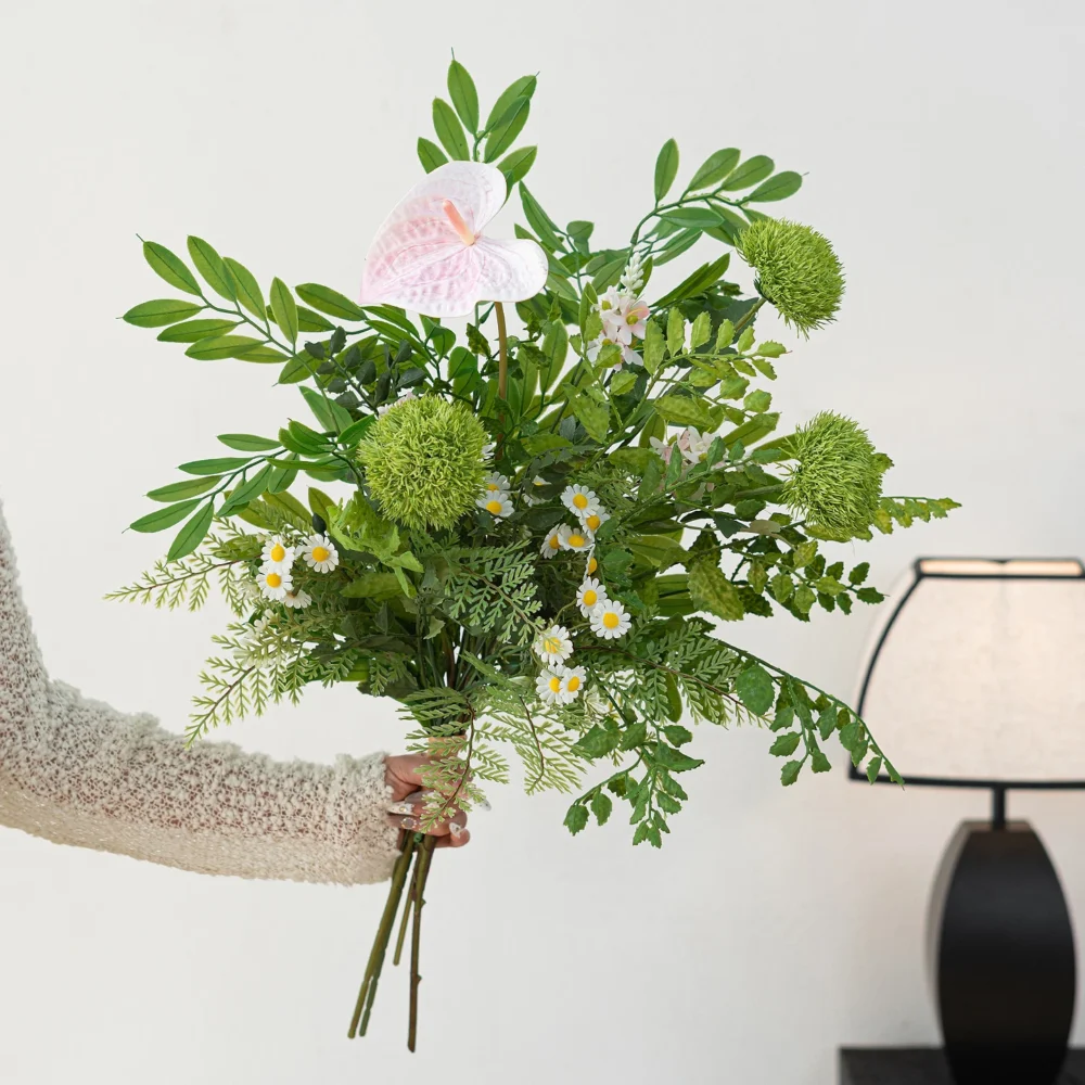 Pink anthurium artificial greenery bunch of mixed ferns, eucalyptus and berry stems, held in one hand