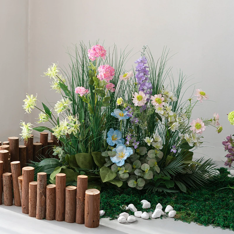 Pink and lilac artificial ornamental grass border on a bark and moss base, styled in a room setting