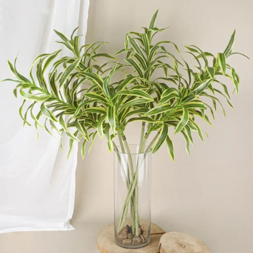 Long trailing artificial spider plant stem with long arching variegated straps, styled in a room setting
