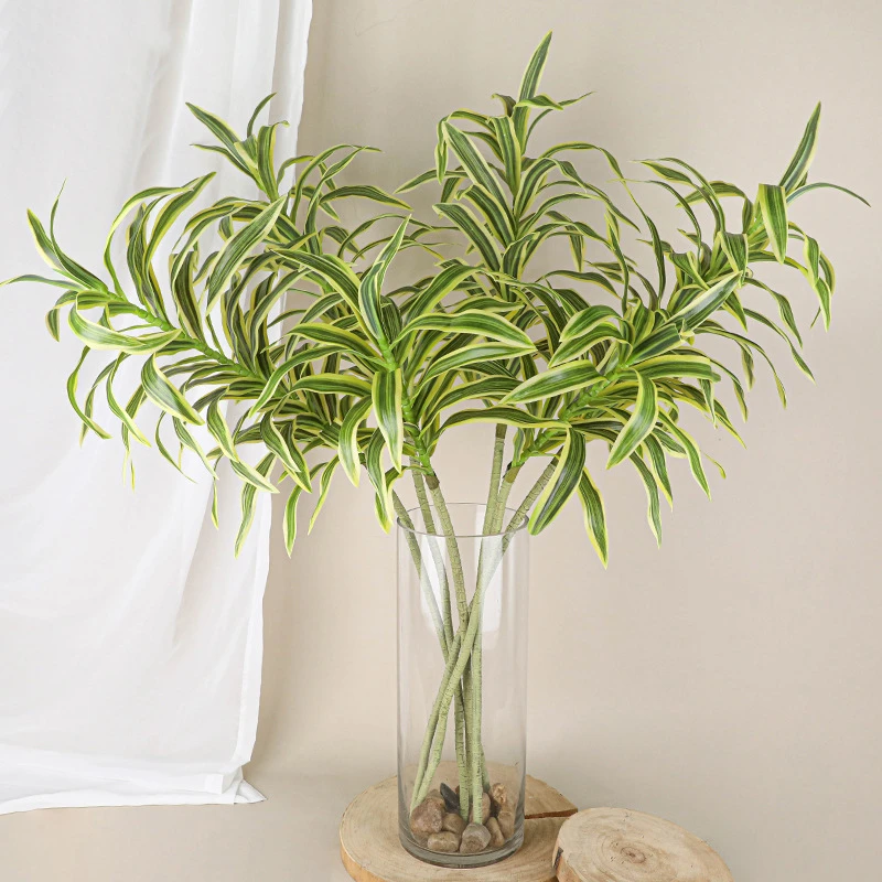 Long trailing artificial spider plant stem with long arching variegated straps, styled in a room setting