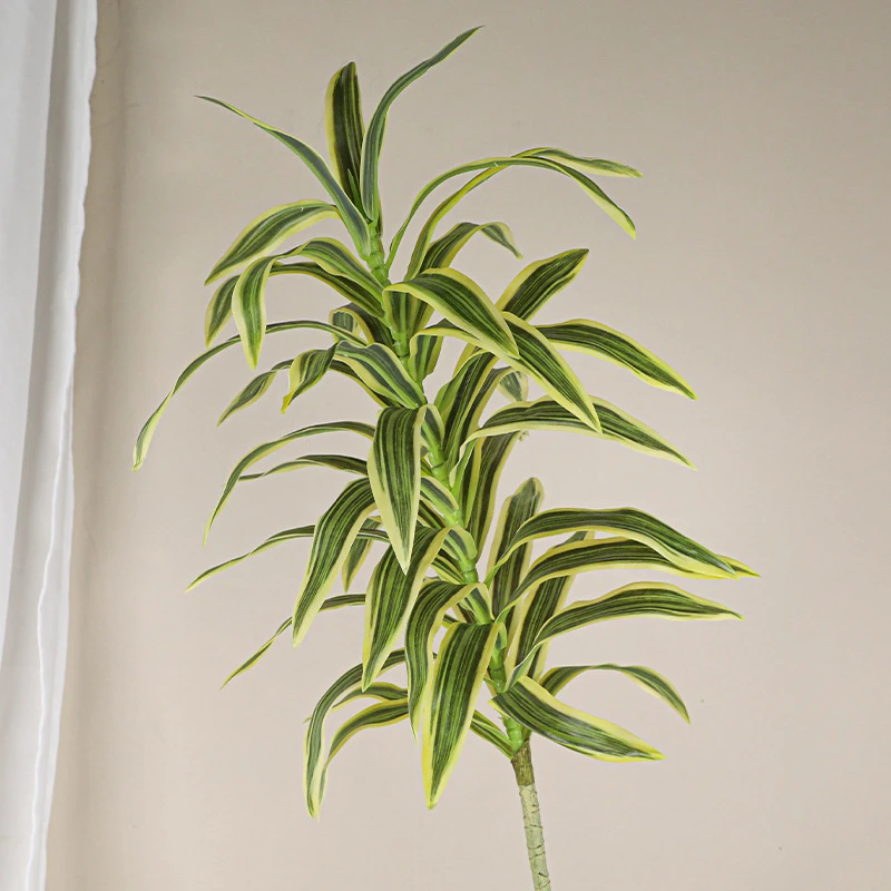 Pale variegated artificial spider plant stem with long arching variegated straps, styled in a room setting