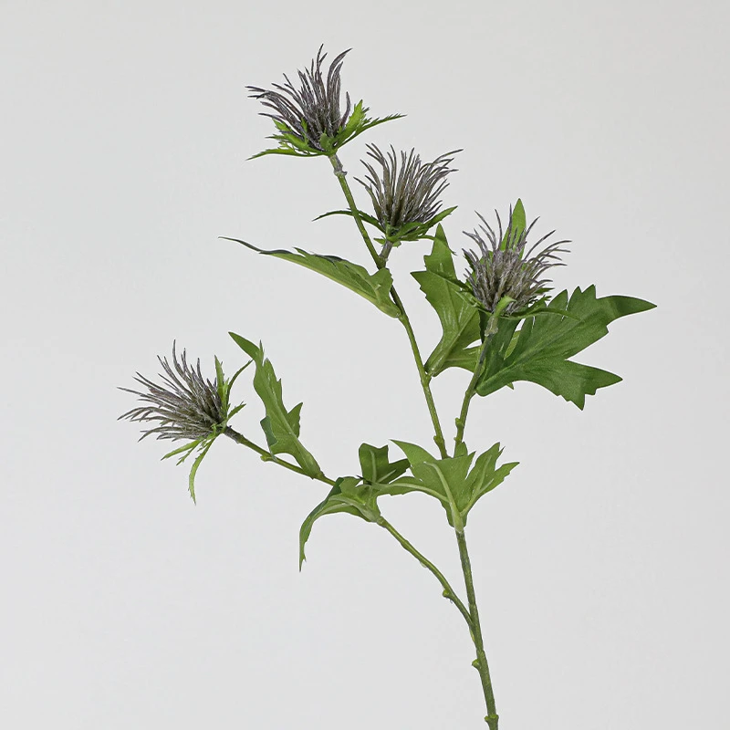 Five heads artificial thistle flower stem with soft lilac crowns sitting above jagged leaves
