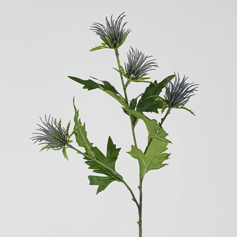 Open stem artificial thistle flower stem with soft lilac crowns sitting above jagged leaves