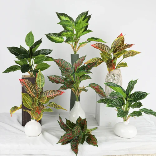 The full range, styled artificial tropical leaf bush of patterned leaves gathered on one short stalk, styled in a room setting
