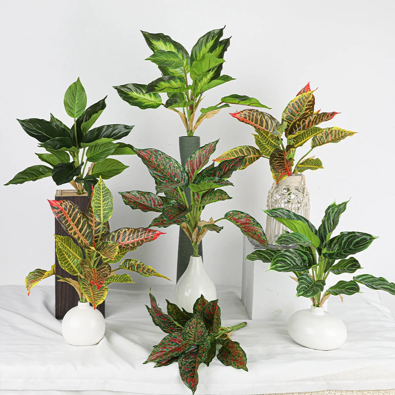 The full range, styled artificial tropical leaf bush of patterned leaves gathered on one short stalk, styled in a room setting