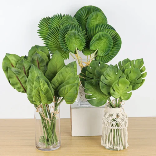 Mixed, in a vase artificial tropical leaf stems of fan palm, monstera and banana leaf, arranged in a vase