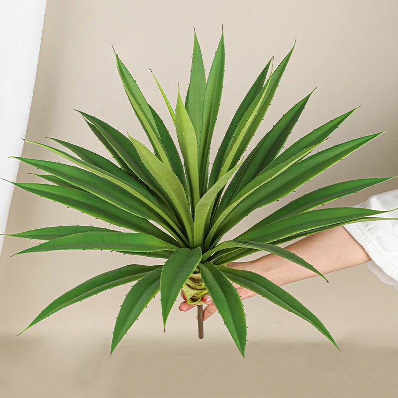 Twin heads artificial yucca leaf head as a single sword-leaved head on a short stub, styled in a room setting