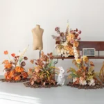 Orange autumn artificial flower arrangement in rust, copper and burnt orange, styled in a room setting