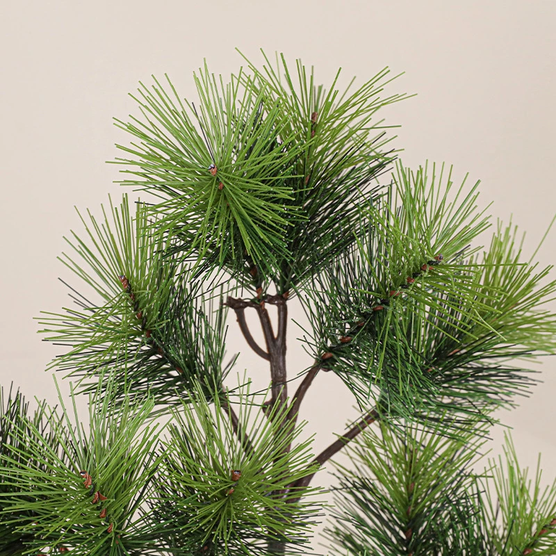 Close up fake pine branch with long soft needles on a bendable stem shown close up