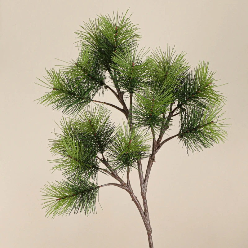 Full branch fake pine branch with long soft needles on a bendable stem, styled on a table top